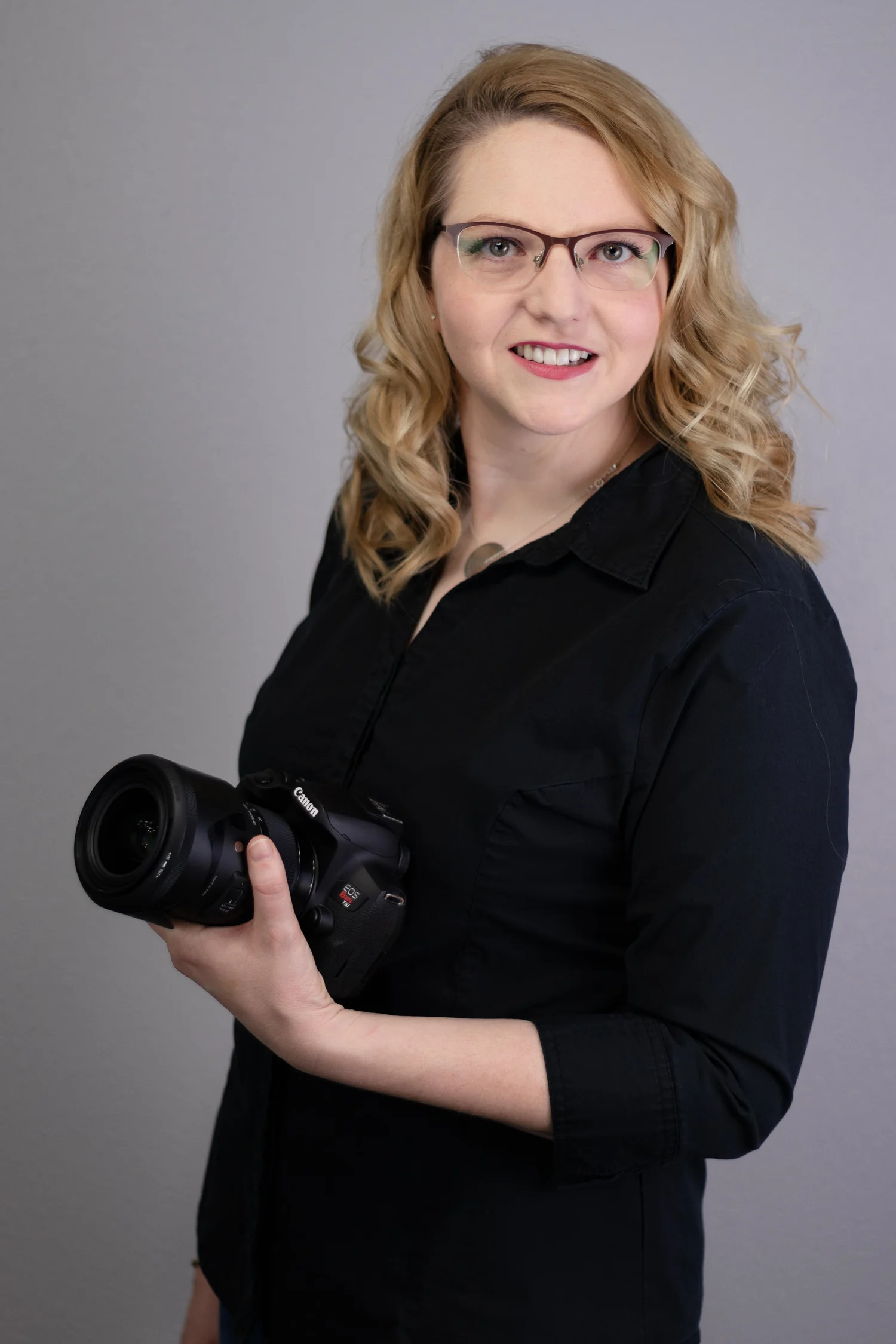 Katherine Ranger of S and K Imagery holding a camera in the studio